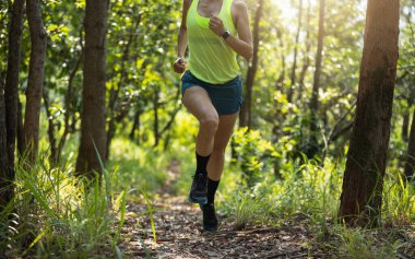 Woman trail runner running at tropical forest mountain peak