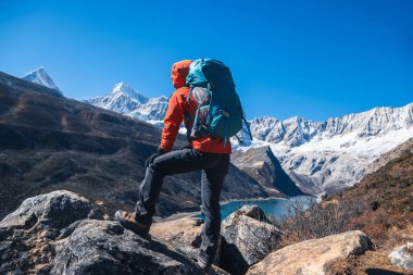 Sırt çantalı bir kadın yüksek irtifada dağ yürüyüşü yapıyor.