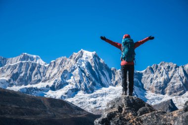 Sırt çantalı bir kadın yüksek irtifada dağ yürüyüşü yapıyor.