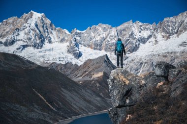 Sırt çantalı bir kadın yüksek irtifada dağ yürüyüşü yapıyor.