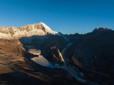 Çin 'in Tibet kentindeki güzel kar kaplı dağ ve göl doğumu manzarası.