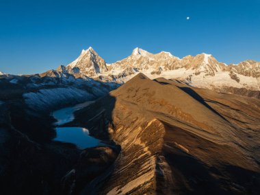 Çin 'in Tibet kentindeki güzel kar kaplı dağ ve göl doğumu manzarası.