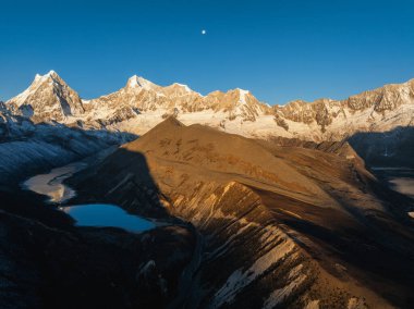Çin 'in Tibet kentindeki güzel kar kaplı dağ ve göl doğumu manzarası.