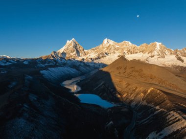 Çin 'in Tibet kentindeki güzel kar kaplı dağ ve göl doğumu manzarası.