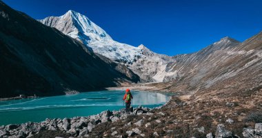 Sırt çantalı bir kadın yüksek rakım dağlarında yürüyüş yapıyor.