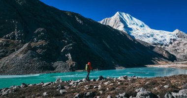 Sırt çantalı bir kadın yüksek rakım dağlarında yürüyüş yapıyor.
