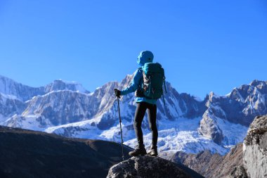 Sırt çantalı bir kadın yüksek irtifada dağ yürüyüşü yapıyor.
