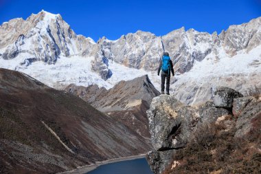 Sırt çantalı bir kadın yüksek irtifada dağ yürüyüşü yapıyor.
