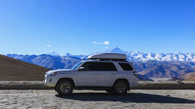 Tibet, Çin 'de yüksek rakımlı bir dağın tepesindeki off-road arabası.