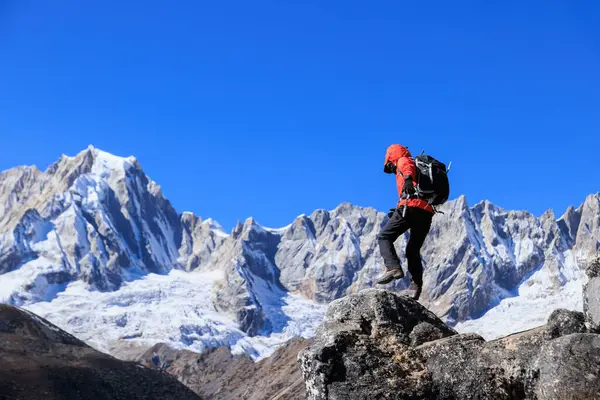 Sırt çantalı bir kadın yüksek irtifadaki dağ tepesindeki spor nöbetlerinde yüksekliği kontrol ediyor.