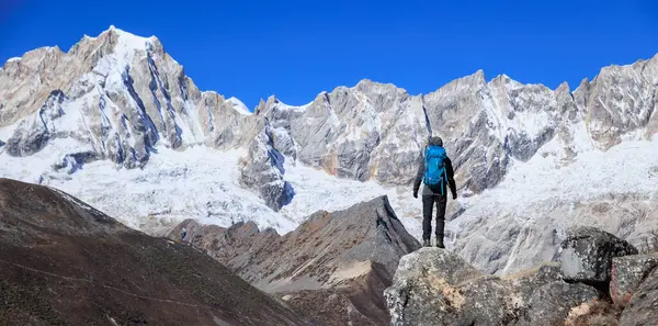 Sırt çantalı bir kadın yüksek irtifada dağ yürüyüşü yapıyor.