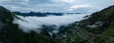 Güzel yüksek irtifa çayırlık dağ ve dolambaçlı yol manzarasının havadan görünüşü