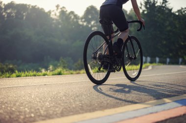 Yaz parkında bisiklet süren bir bisikletçi.