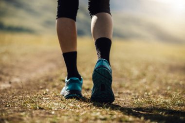 Yüksek irtifada yürüyen kadın bacakları otlaklar dağ yolunda yürüyor.