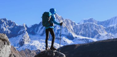 Sırt çantalı bir kadın yüksek irtifada dağ yürüyüşü yapıyor.