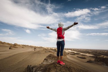 Successful woman trail runner open arms on sand desert dunes clipart