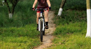 Dağ yolunda bisiklet süren kadın.