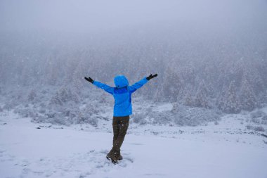 Asyalı kadın güzel kar manzarasının tadını çıkarıyor.