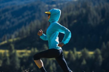 Fitness Asyalı kadın koşucu gün doğumunda otlakta koşuyor