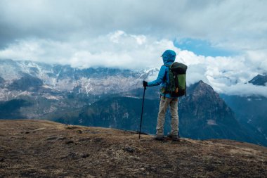 Sırt çantalı bir kadın yüksek irtifada dağ yürüyüşü yapıyor.