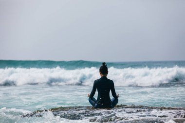 Yaklaşan güçlü deniz dalgaları bakan sahil uçurum kenarında Yoga kadın meditasyon