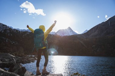 Sırt çantalı kadın, güzel gün batımının tadını çıkar.
