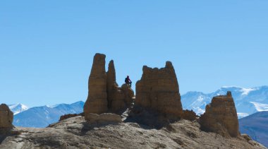 Yürüyüşçü terk edilmiş bir kalede oturur Tibet, Çin 'deki Everest Dağı manzarasının tadını çıkarır.