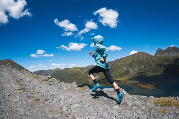 Güzel bir dağın tepesinde koşan fitness kadın koşucu 