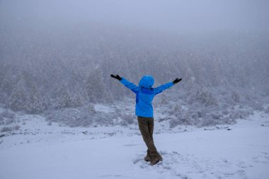 Mutlu kadın güzel kar manzarasının tadını çıkarıyor.