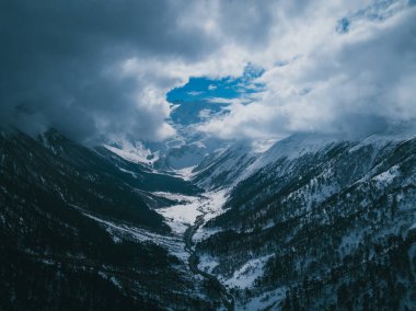 Güzel yüksek irtifa, karlı dağlar ve orman manzarasının havadan görüntüsü.