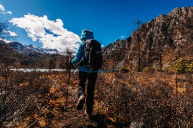 Sırt çantalı bir kadın güzel günbatımında yürüyor 