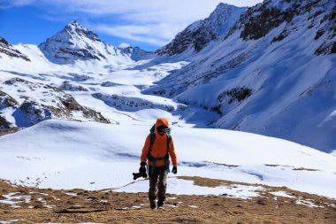Yükseklik dağının tepesinde sırt çantalı kadın fotoğrafçı.
