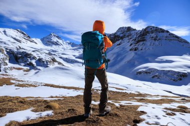Yükseklik dağının tepesinde sırt çantalı kadın fotoğrafçı.