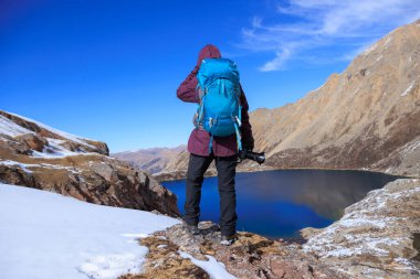 Yükseklik dağının tepesinde sırt çantalı kadın fotoğrafçı.