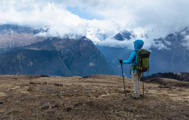 Sırt çantalı bir kadın yüksek irtifada dağ yürüyüşü yapıyor.