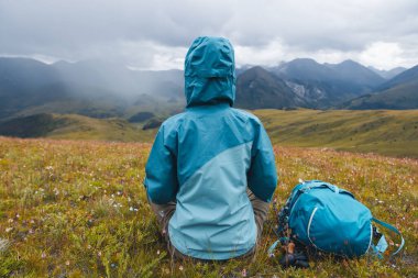 Yüksek rakımlı dağın tepesindeki çayırlarda kadın yürüyüşçülerin meditasyonu