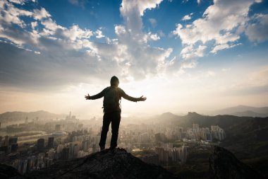 Başarılı kadın yürüyüşçü uçurumun kenarında duruyor kollarını uzatarak güzel Hong Kong 'a doğru.
