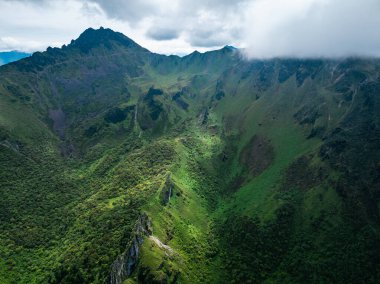 Puslu dağlarla çevrili yemyeşil bir vadi.