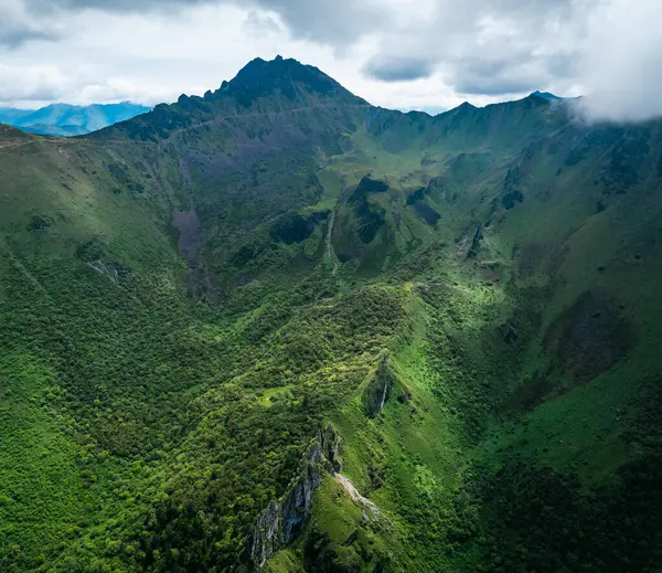 Yüksek dağlarla çevrili yemyeşil bir vadi.