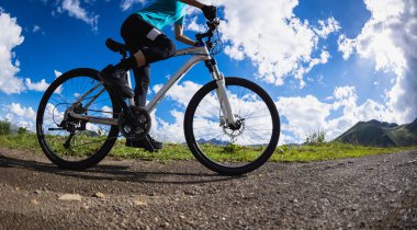 Güzel dağlarda bisiklet süren bir kadın 