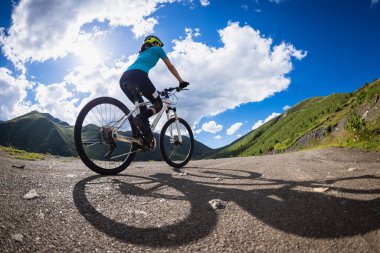 Güzel dağlarda bisiklet süren bir kadın 
