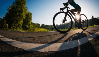 Yaz parkında bisiklet süren bir kadın.