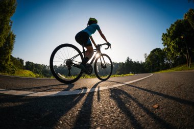 Yaz parkında bisiklet süren bir kadın. 