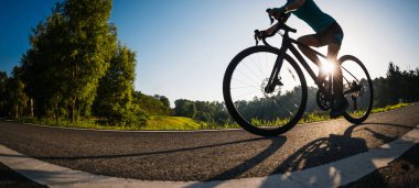 Yaz parkında bisiklet süren bir kadın.