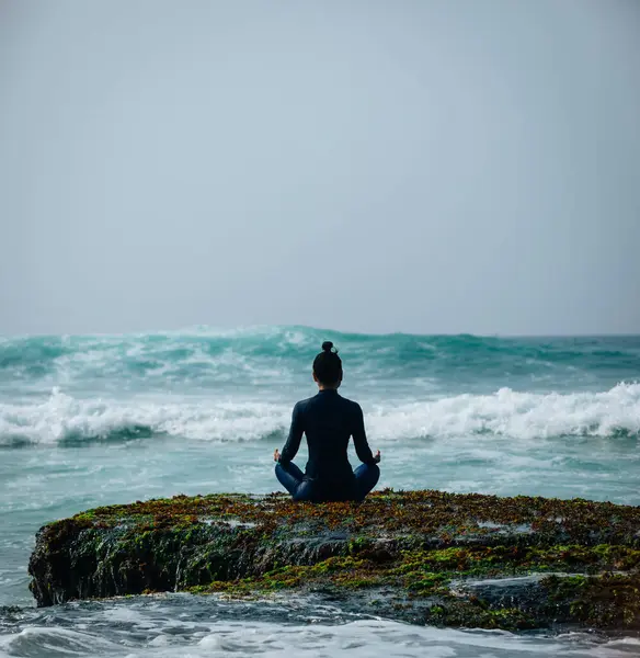 Yaklaşan güçlü deniz dalgaları bakan sahil uçurum kenarında Yoga kadın meditasyon