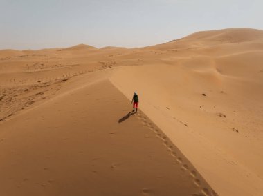 Çölde sırt çantası taşıyan bir kadın.
