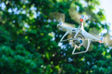 Yaz ormanlarında uçan kameralı beyaz dron