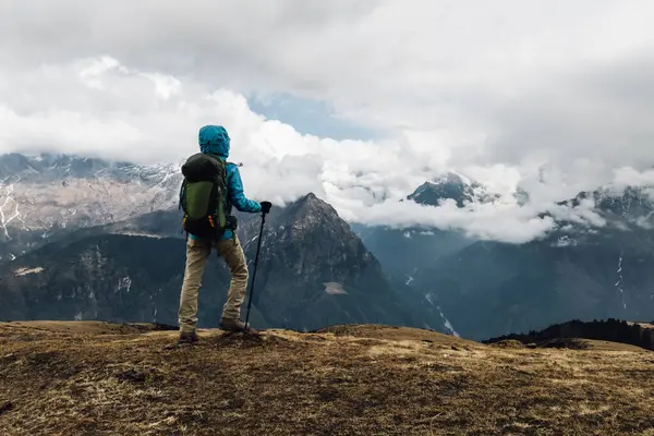 Sırt çantalı bir kadın yüksek irtifada dağ yürüyüşü yapıyor. 