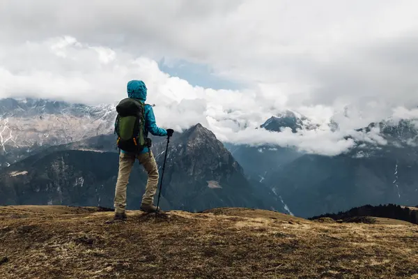 Sırt çantalı bir kadın yüksek irtifada dağ yürüyüşü yapıyor. 