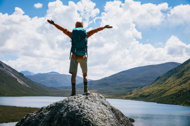 Sırt çantalı kadın yüksek irtifada kollarını aç. 